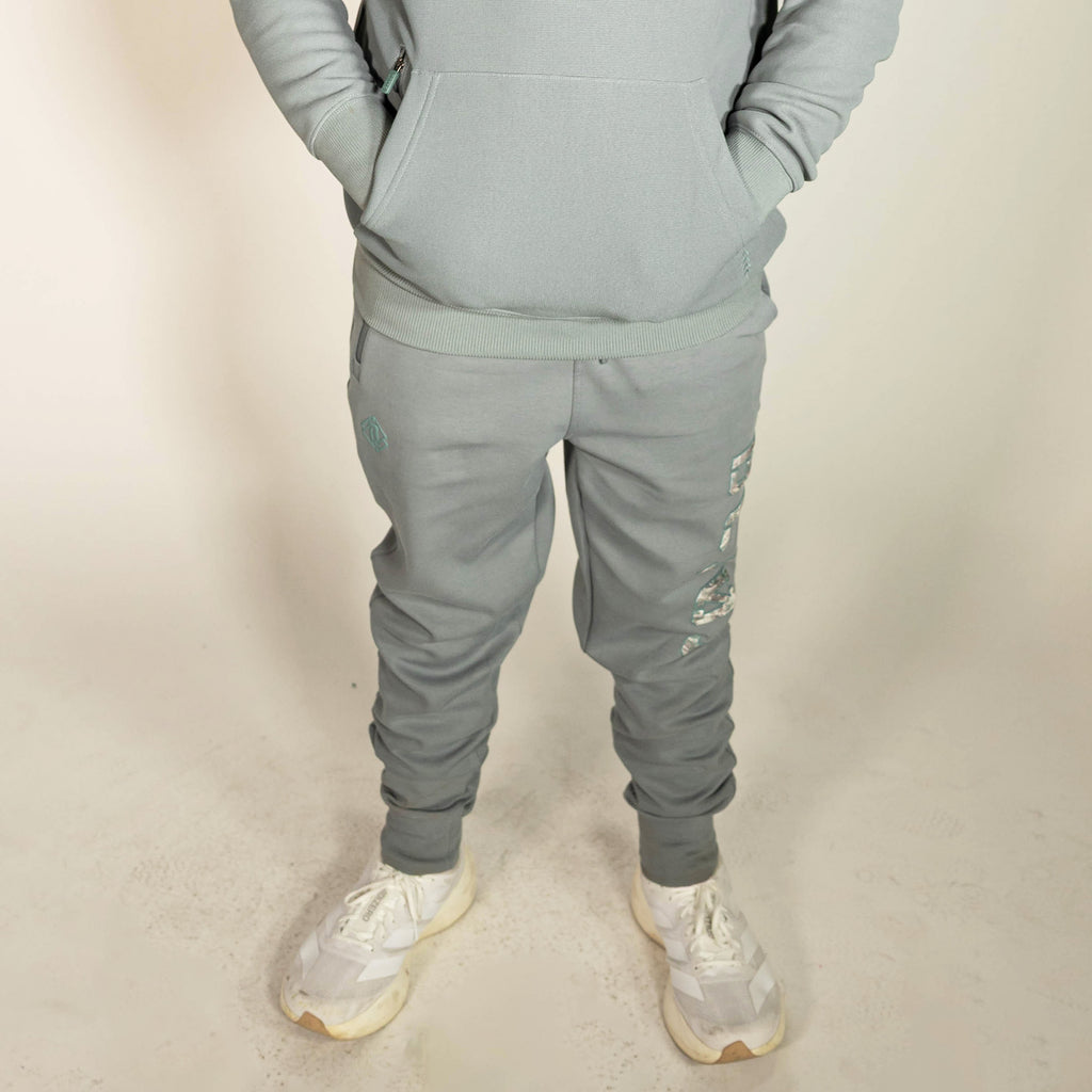 Youth model wearing gray Realtree Aspect Diamond Relaxed Fit Camo youth joggers
