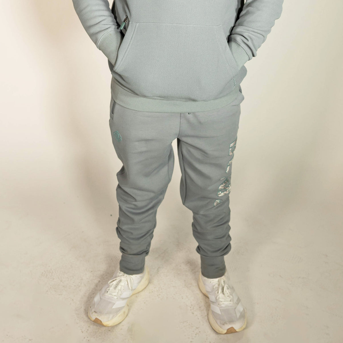 Youth model wearing gray Realtree Aspect Diamond Relaxed Fit Camo youth joggers