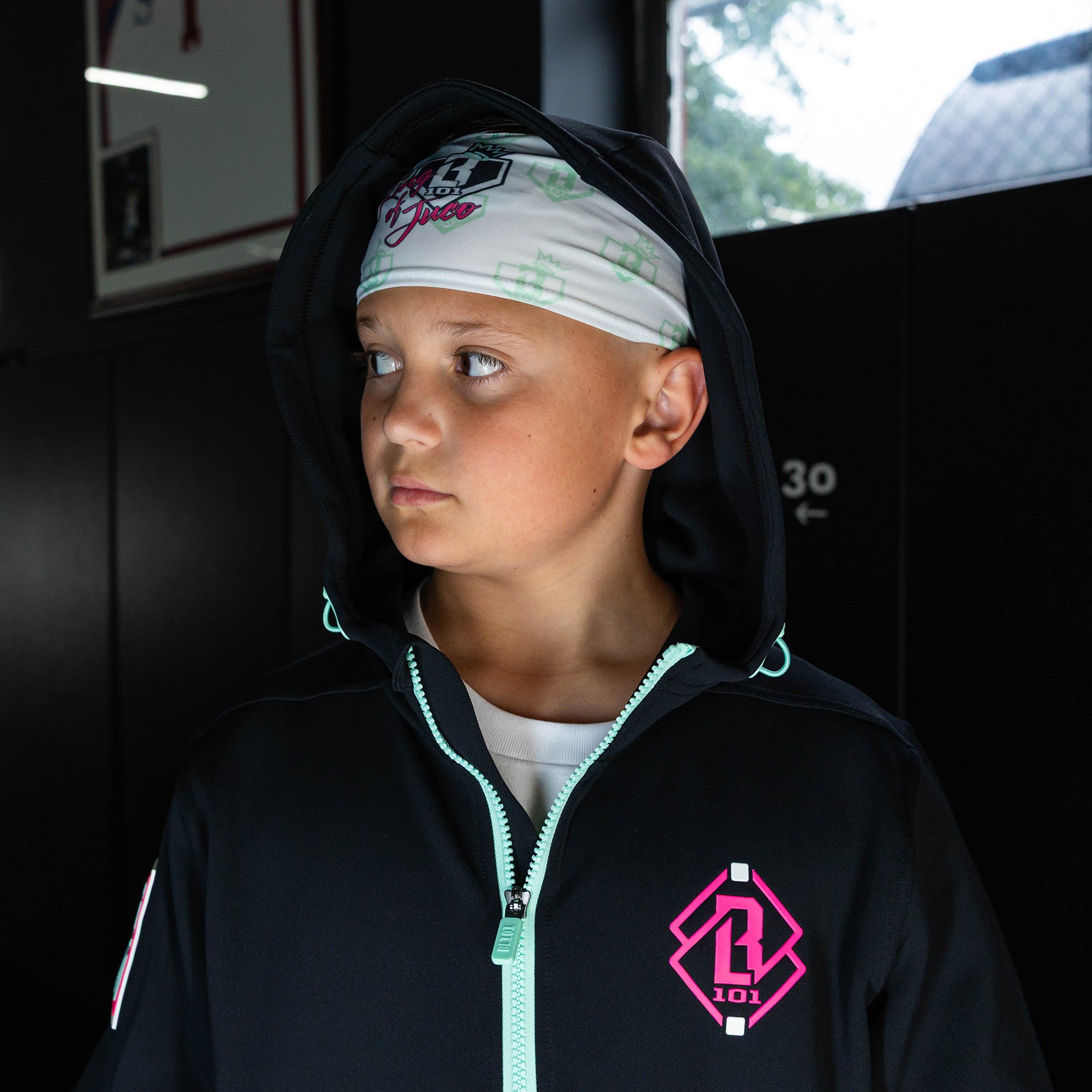 Youth model wearing white headband with "BL101 X Eric Sim" design