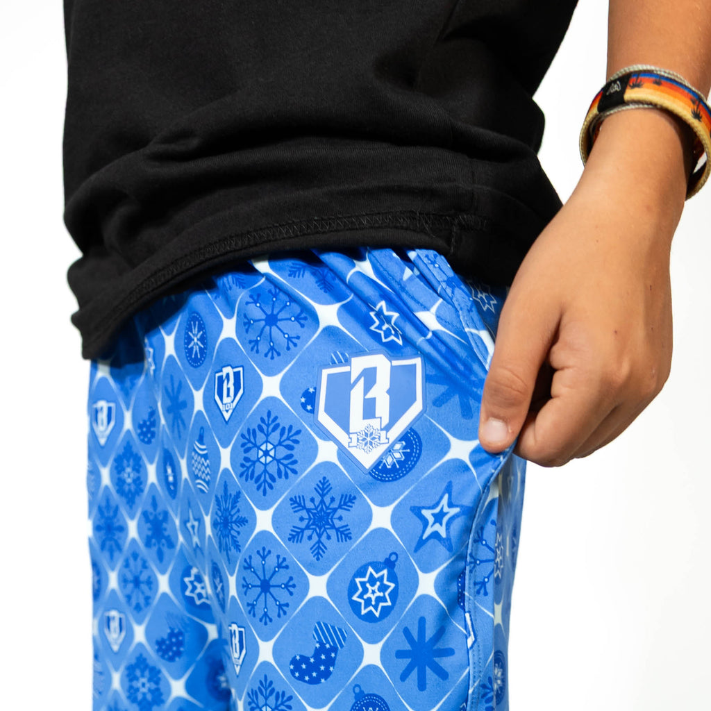Youth model wearing blue youth pajama pants with "Frozen Diamond" design