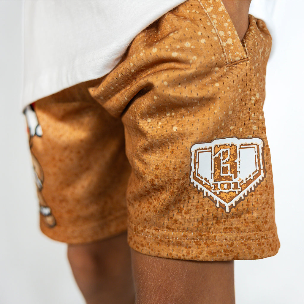 Youth model wearing brown youth shorts with "Gingerbread Rookie" design
