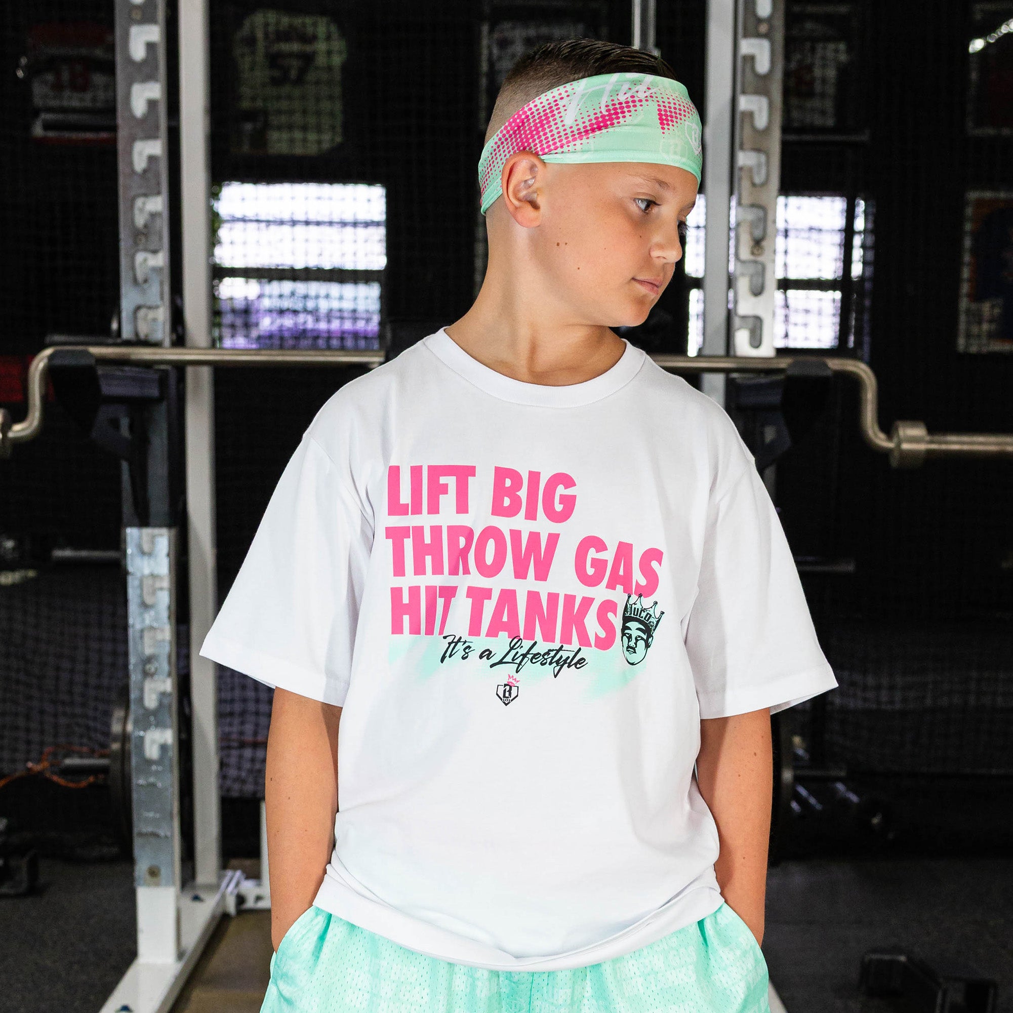 Youth model wearing teal headband with "Hit Tanks" design