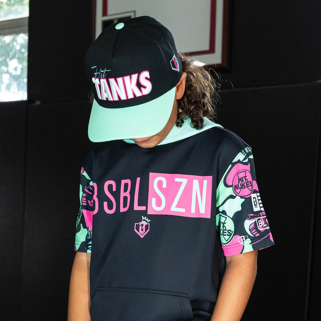 Youth model wearing black hat with "Hit Tanks" design