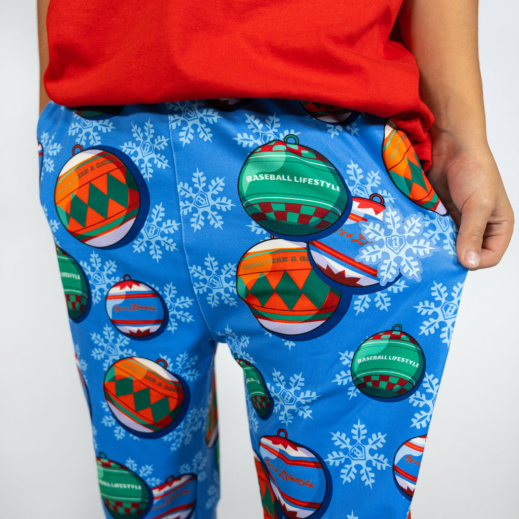 Youth model wearing blue youth pajama pants with "Jingle Ballers" design
