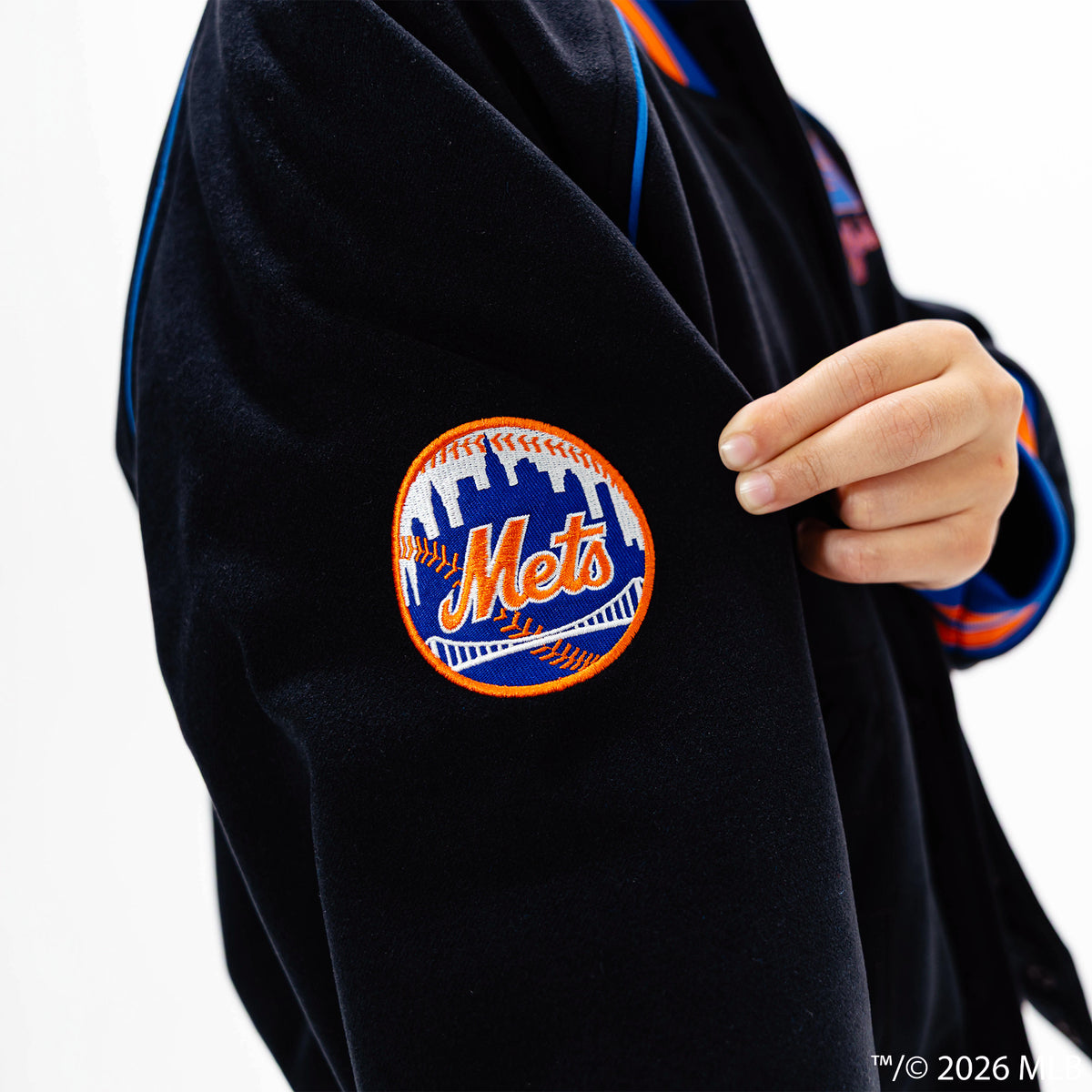 Youth model wearing black New York Mets Stadium youth bomber jacket