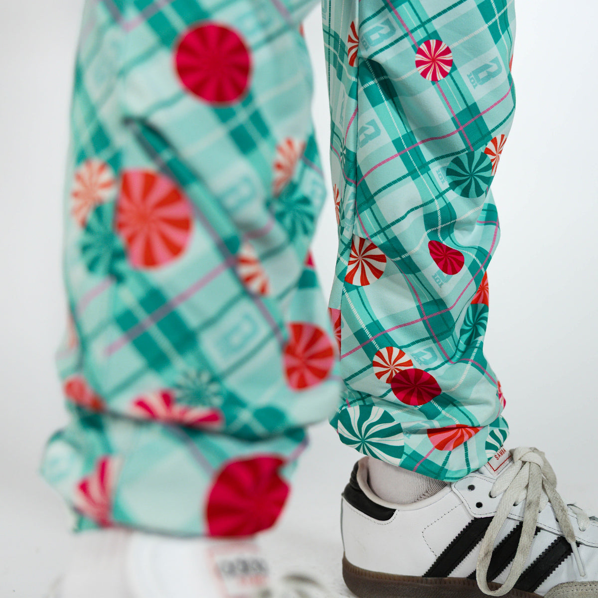 Youth model wearing multi-color youth pajama pants with "Peppermint Plaid" design