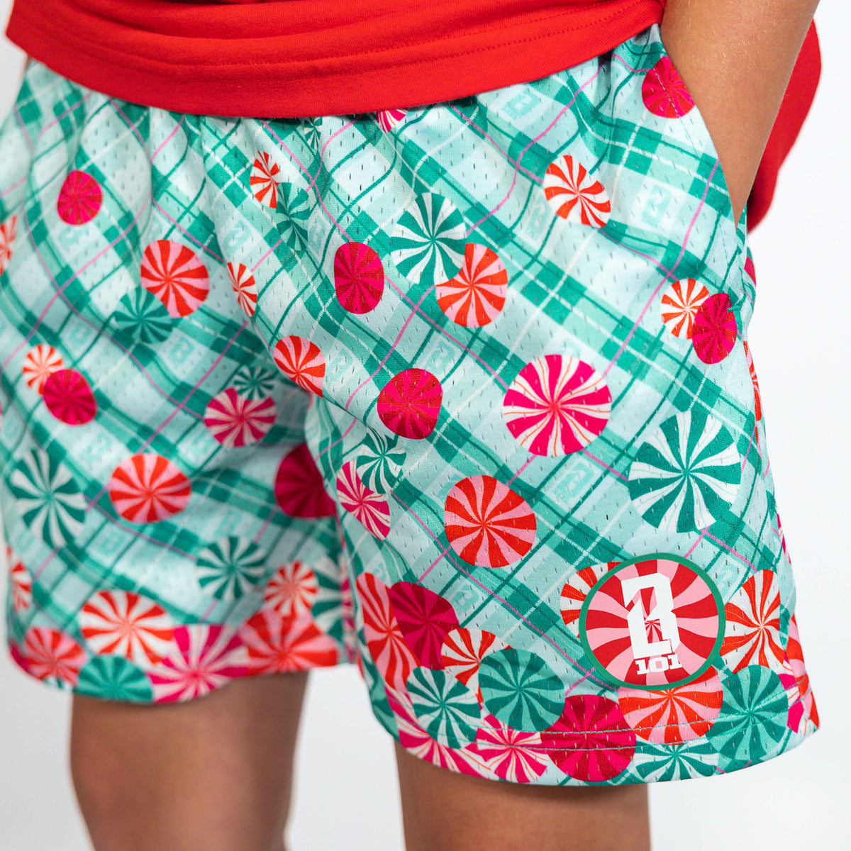 Youth model wearing teal youth shorts with "Peppermint Plaid" design