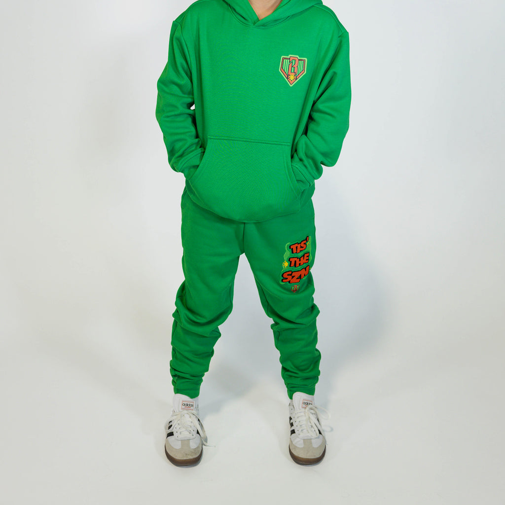 Youth model wearing green youth sweatpants with "Tis The SZN" design