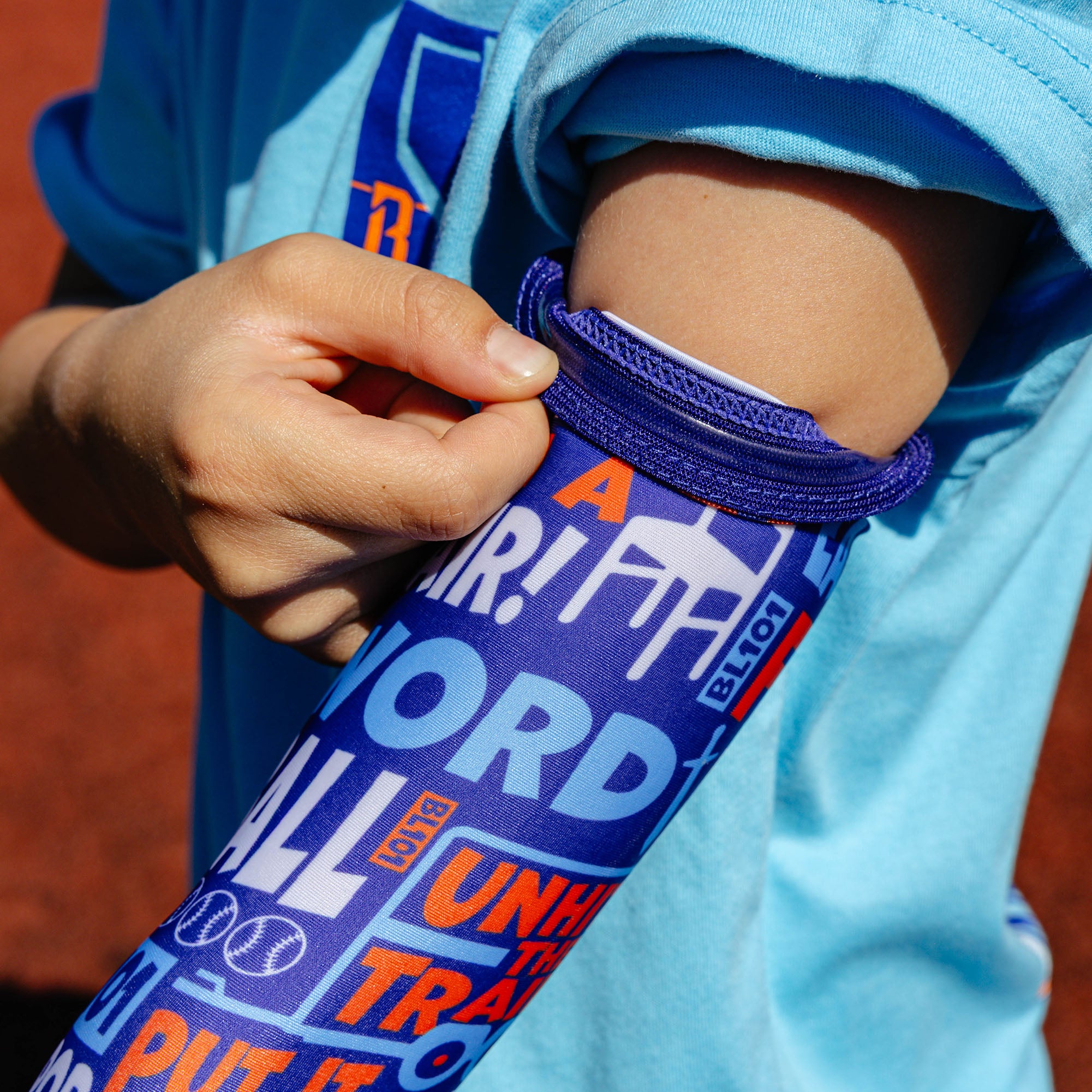 Youth model wearing multi-color youth arm sleeve with "Trash Talk Youth" design