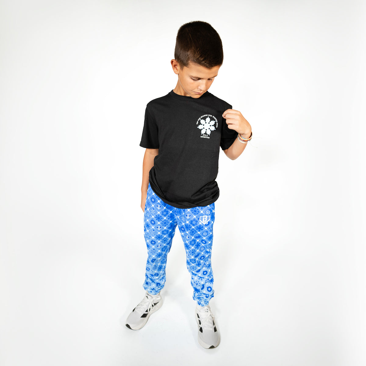 Youth model wearing blue youth pajama pants with "Frozen Diamond" design