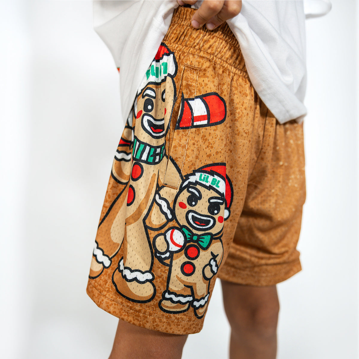 Youth model wearing brown youth shorts with "Gingerbread Rookie" design