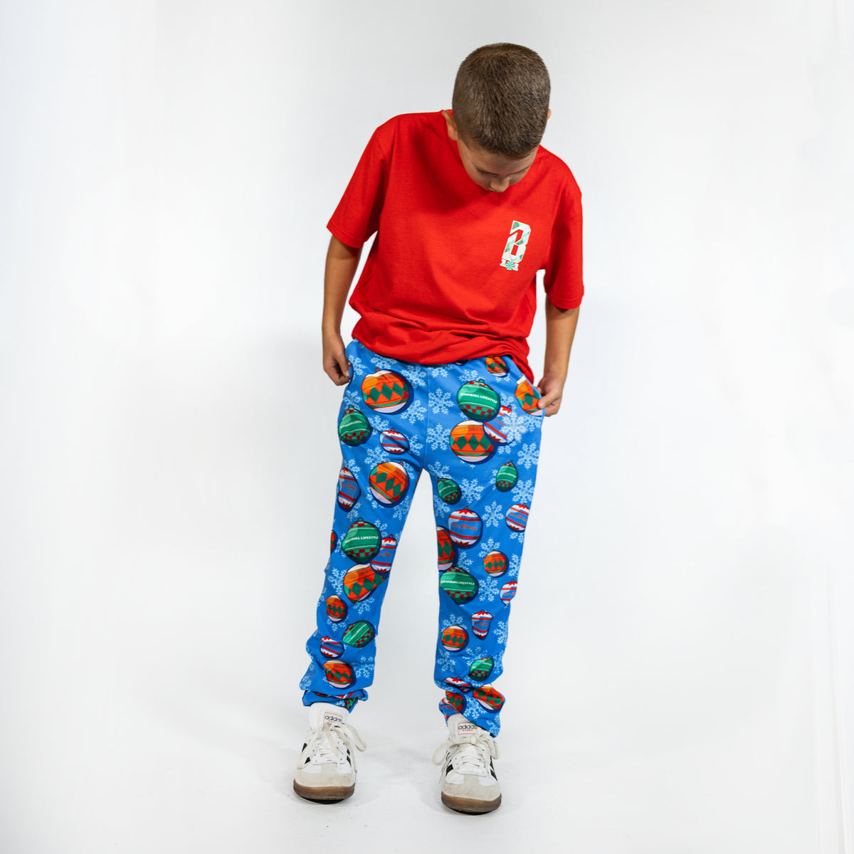 Youth model wearing blue youth pajama pants with "Jingle Ballers" design