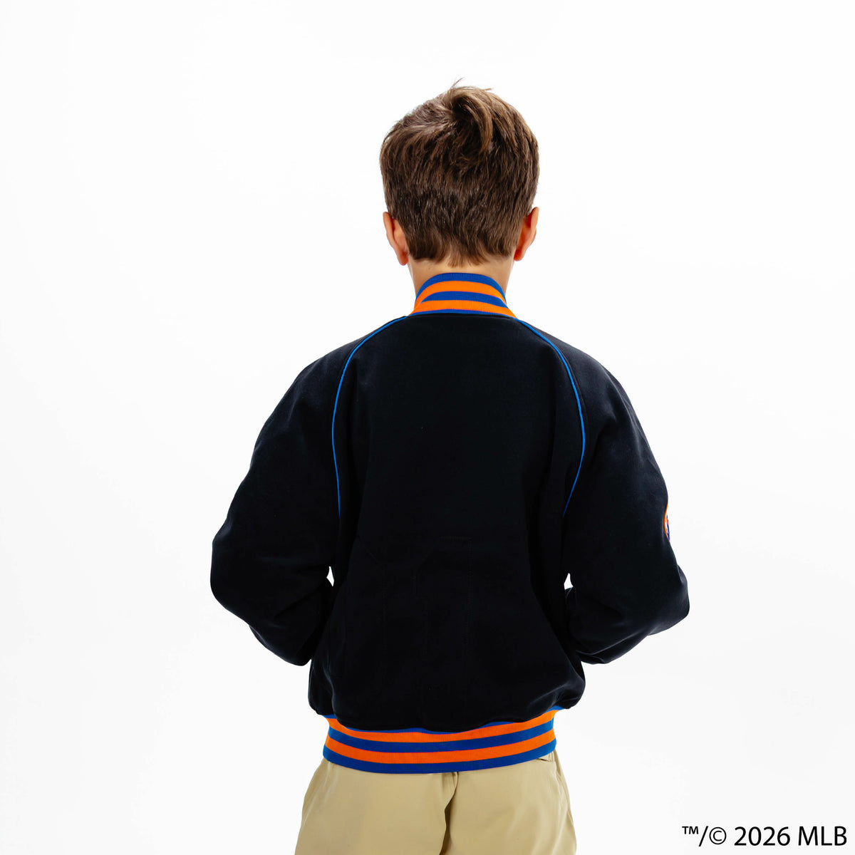 Youth model wearing black New York Mets Stadium youth bomber jacket