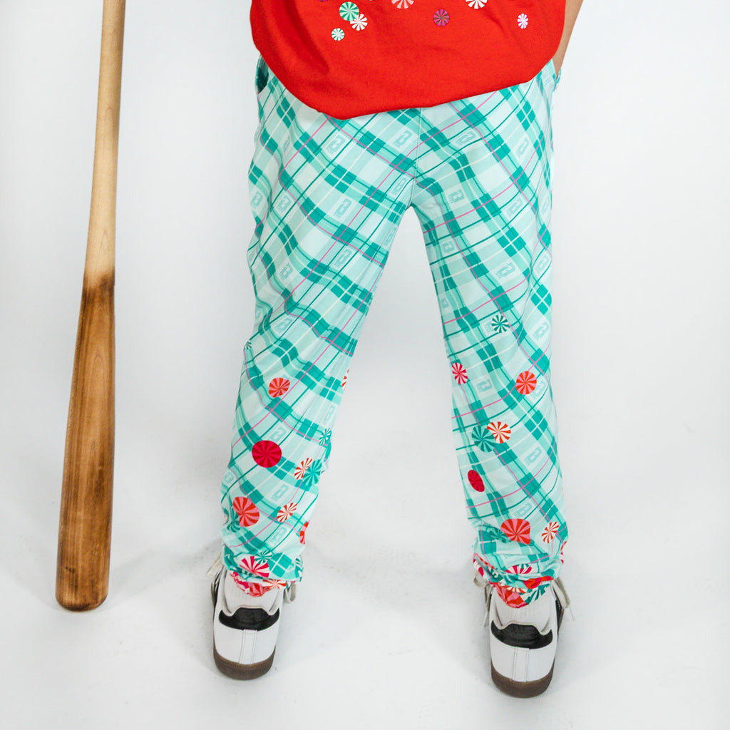 Youth model wearing multi-color youth pajama pants with "Peppermint Plaid" design