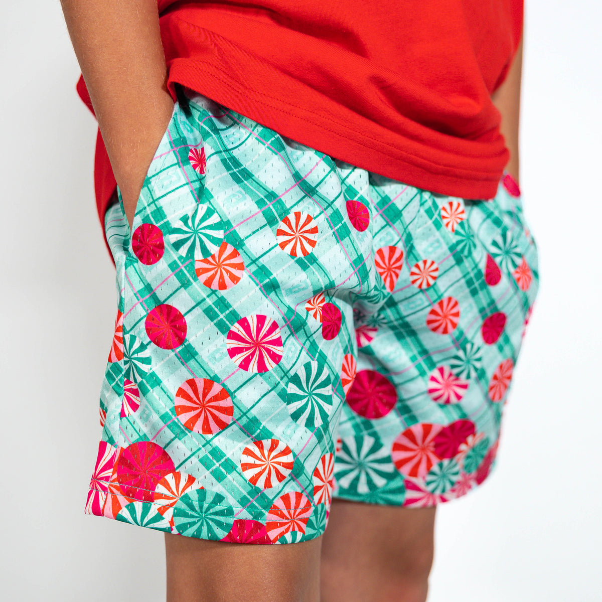 Youth model wearing teal youth shorts with "Peppermint Plaid" design