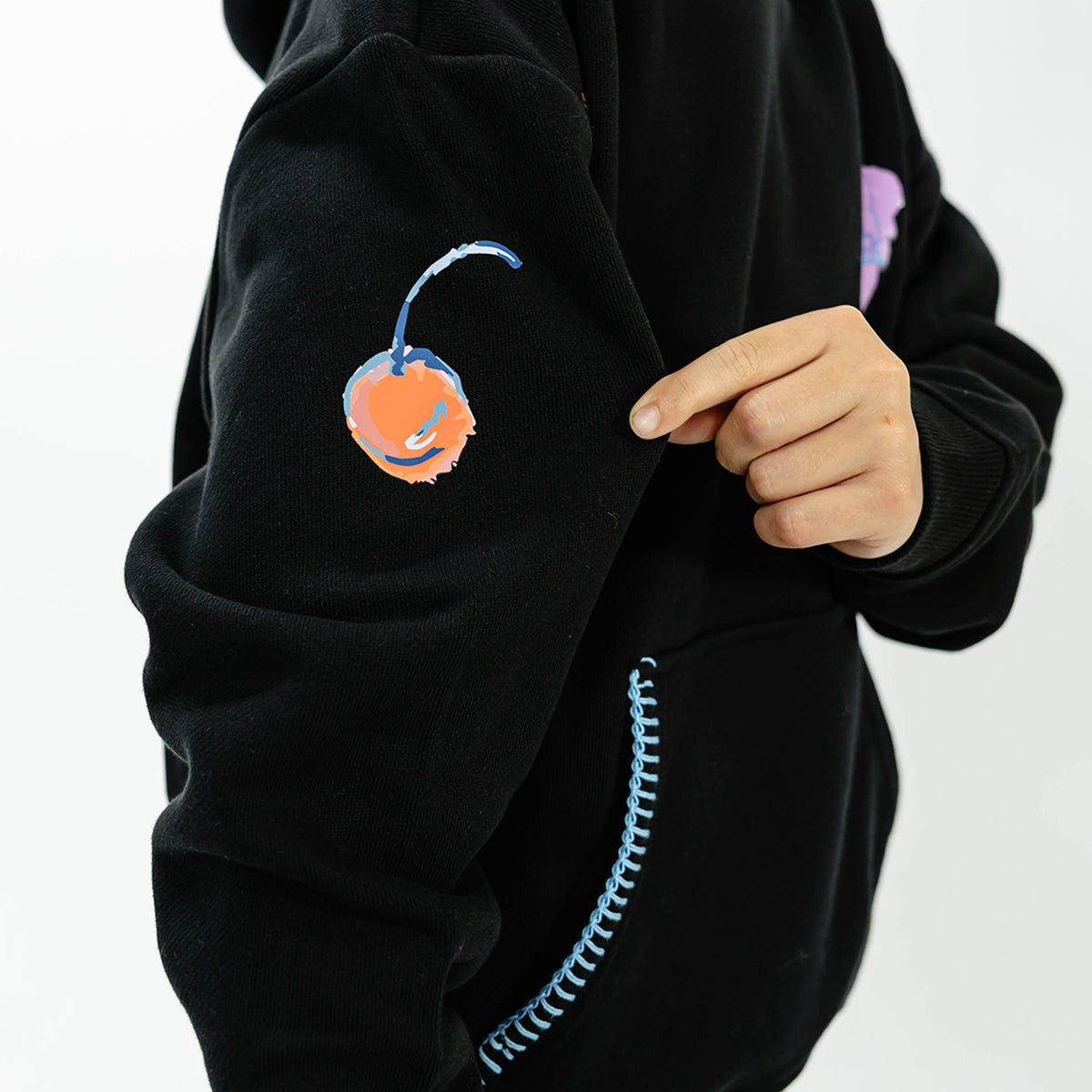 Youth model wearing black youth hoodie with "Fastball Scoops" design