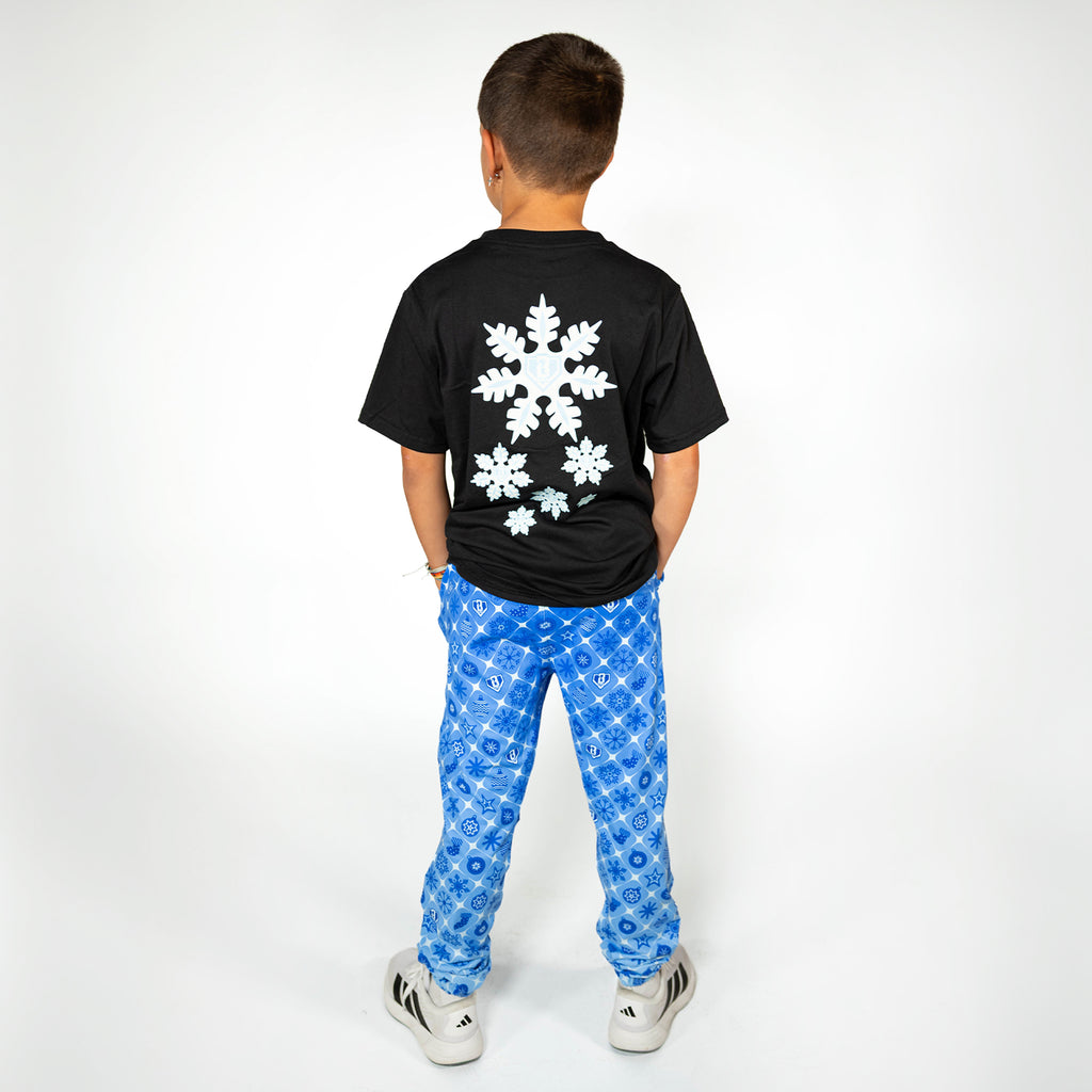 Youth model wearing blue youth pajama pants with "Frozen Diamond" design