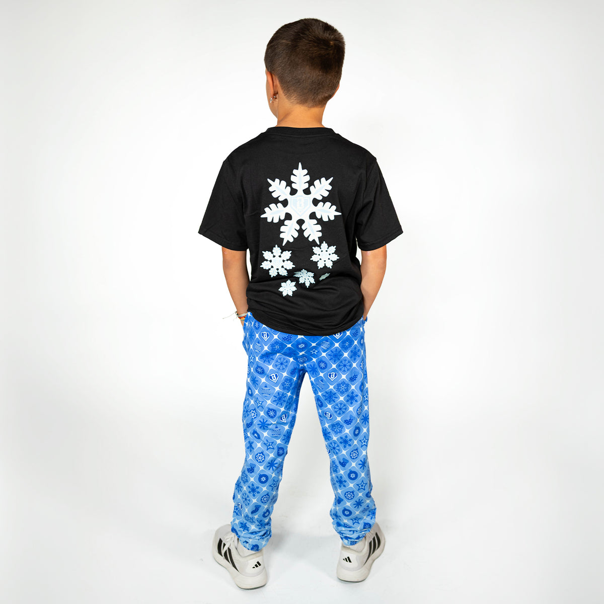 Youth model wearing blue youth pajama pants with "Frozen Diamond" design