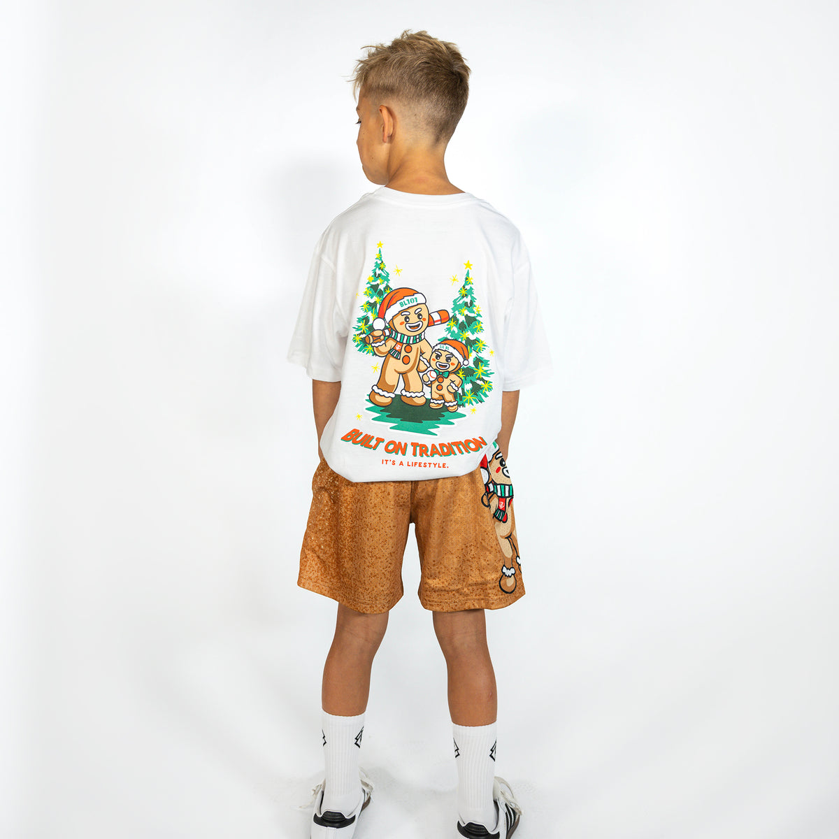 Youth model wearing brown youth shorts with "Gingerbread Rookie" design