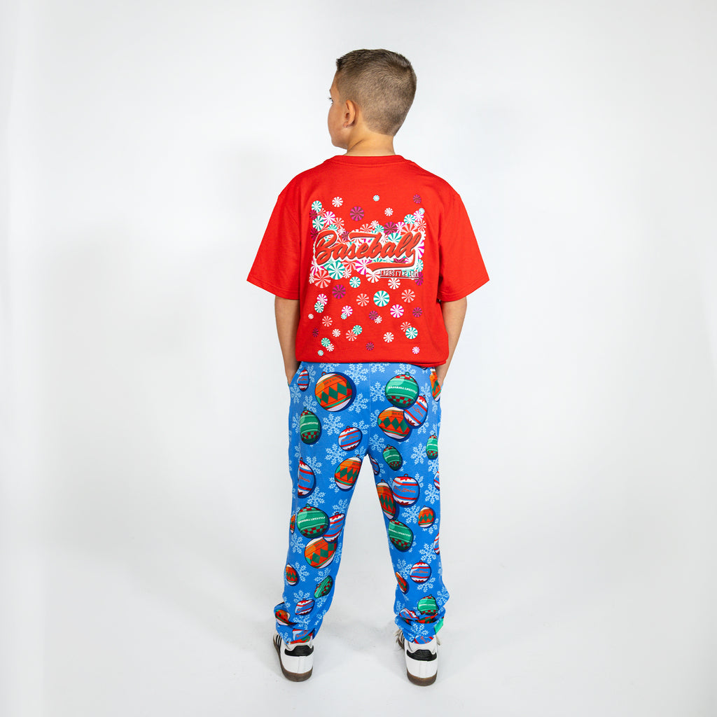 Youth model wearing blue youth pajama pants with "Jingle Ballers" design