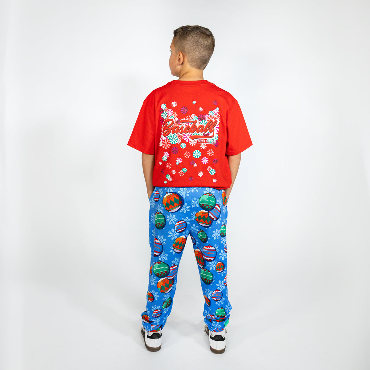 Youth model wearing blue youth pajama pants with "Jingle Ballers" design