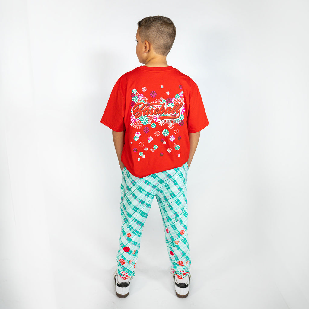 Youth model wearing multi-color youth pajama pants with "Peppermint Plaid" design