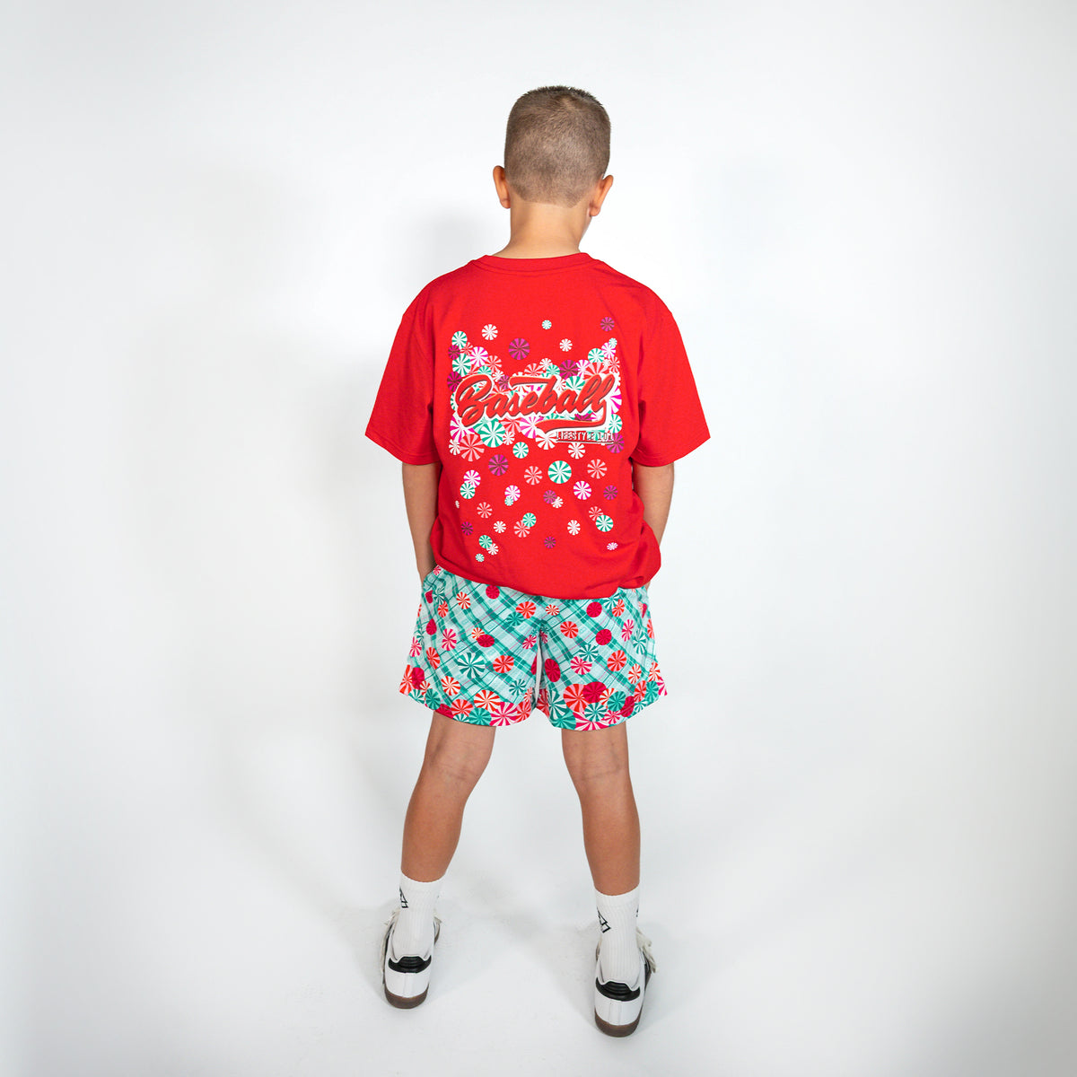 Youth model wearing teal youth shorts with "Peppermint Plaid" design