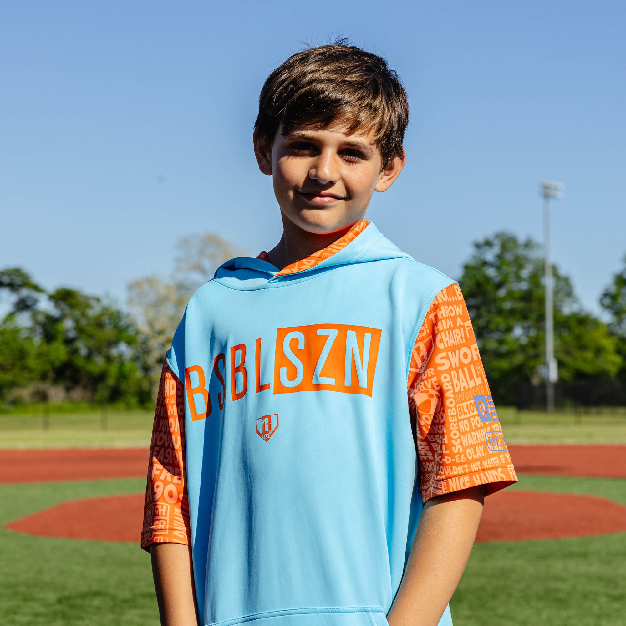Youth model wearing blue youth short sleeve hoodie with "BSBL-SZN V3 Short Sleeve Youth" design