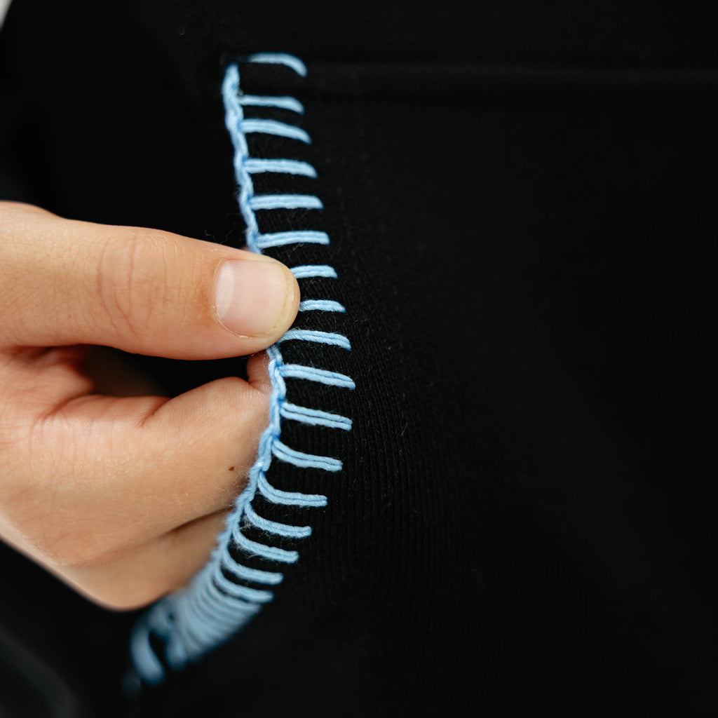 Youth model wearing black youth hoodie with "Fastball Scoops" design