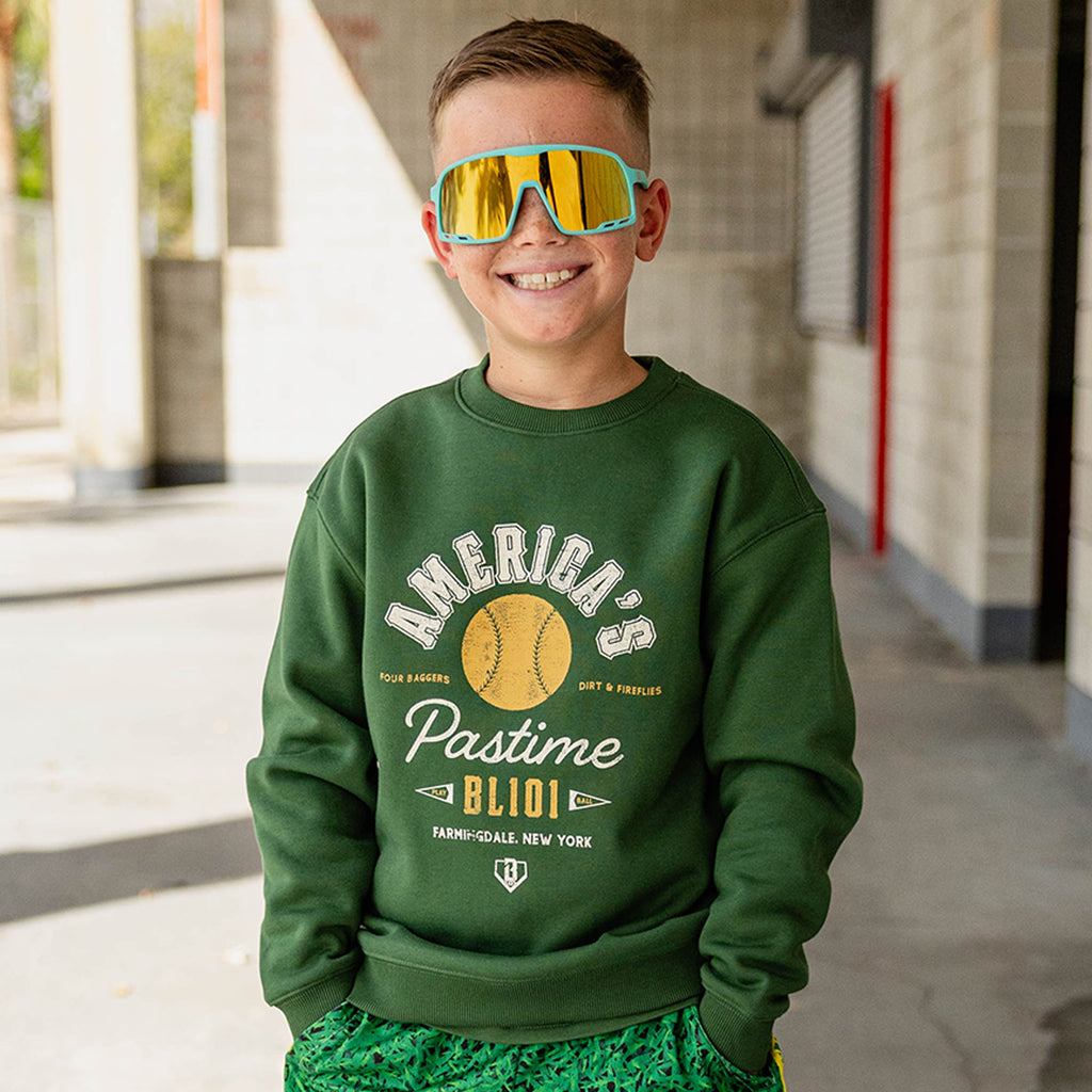 Child wearing a forest green America's Pastime crewneck sweatshirt.
