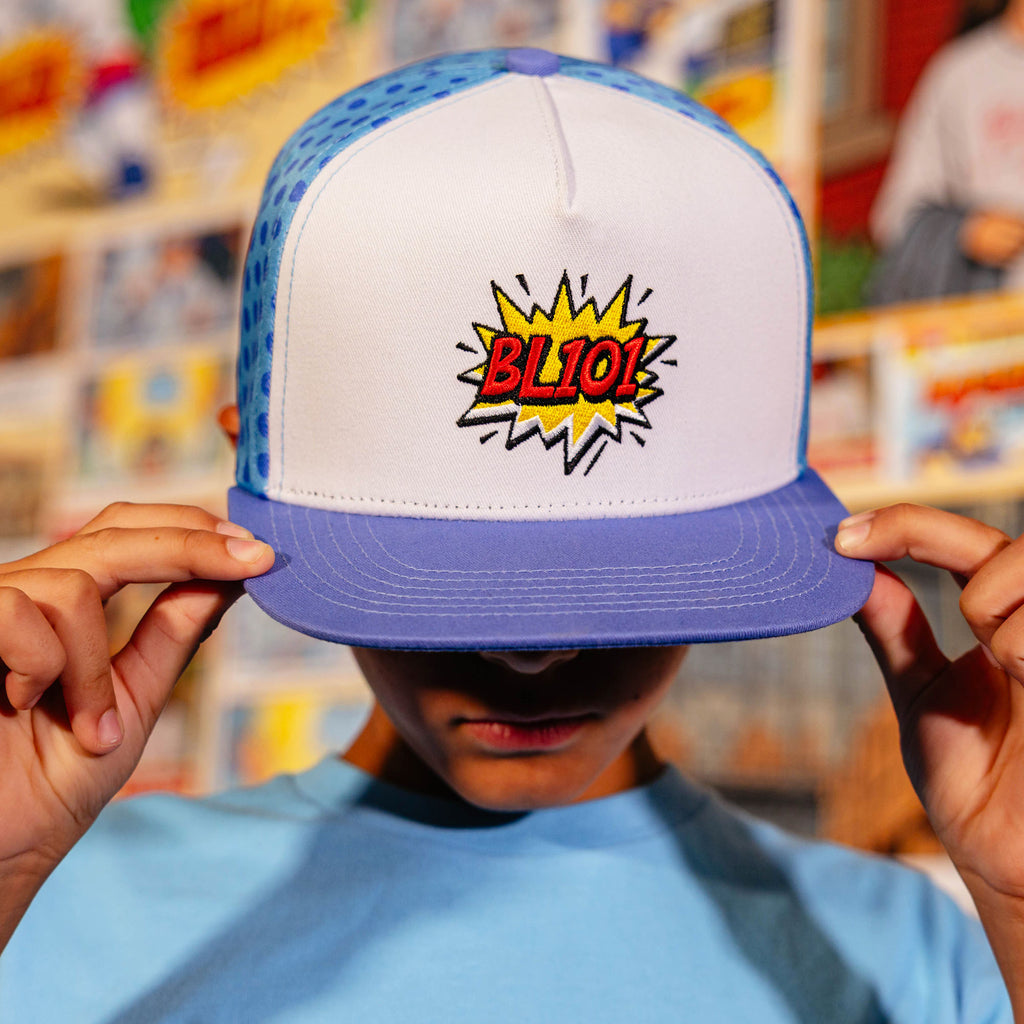 Youth model wearing blue hat with "BL101 Comic" design