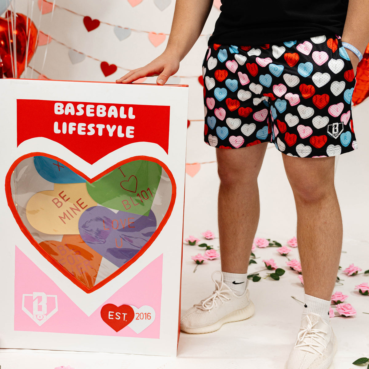 Person wearing heart-patterned shorts next to a 'Baseball Lifestyle' box with heart designs.