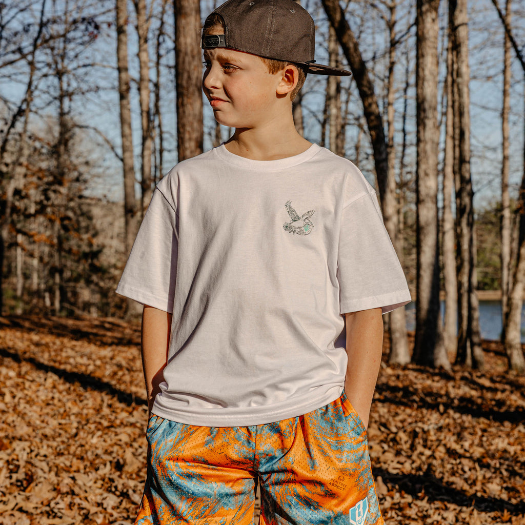 Youth model wearing white youth graphic tee with “Fowl Territory” design