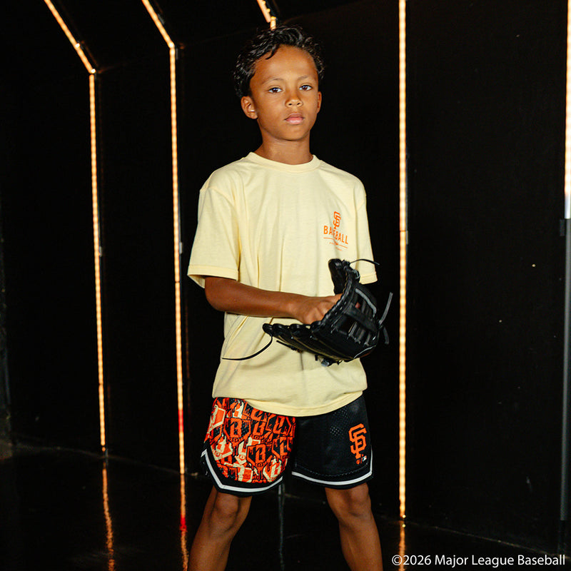 Youth model wearing black youth shorts with "San Francisco Giants Sticker Court" design