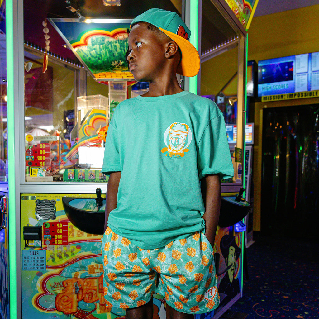 Youth model wearing Home Run Sugar Tangerine Freeze youth shorts