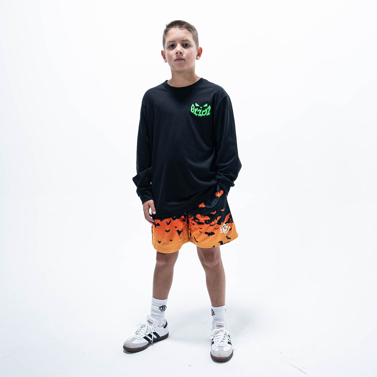 Youth model wearing black youth long sleeve tee with "Jack O' Lantern Team" design