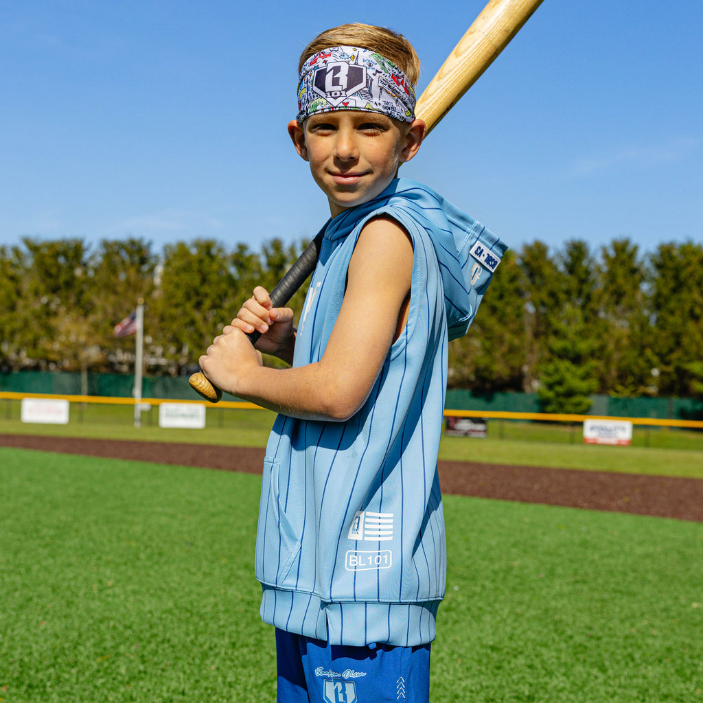 Youth player on a baseball field holding a bat, wearing the Jackson Olson x BL101 white graphic headband