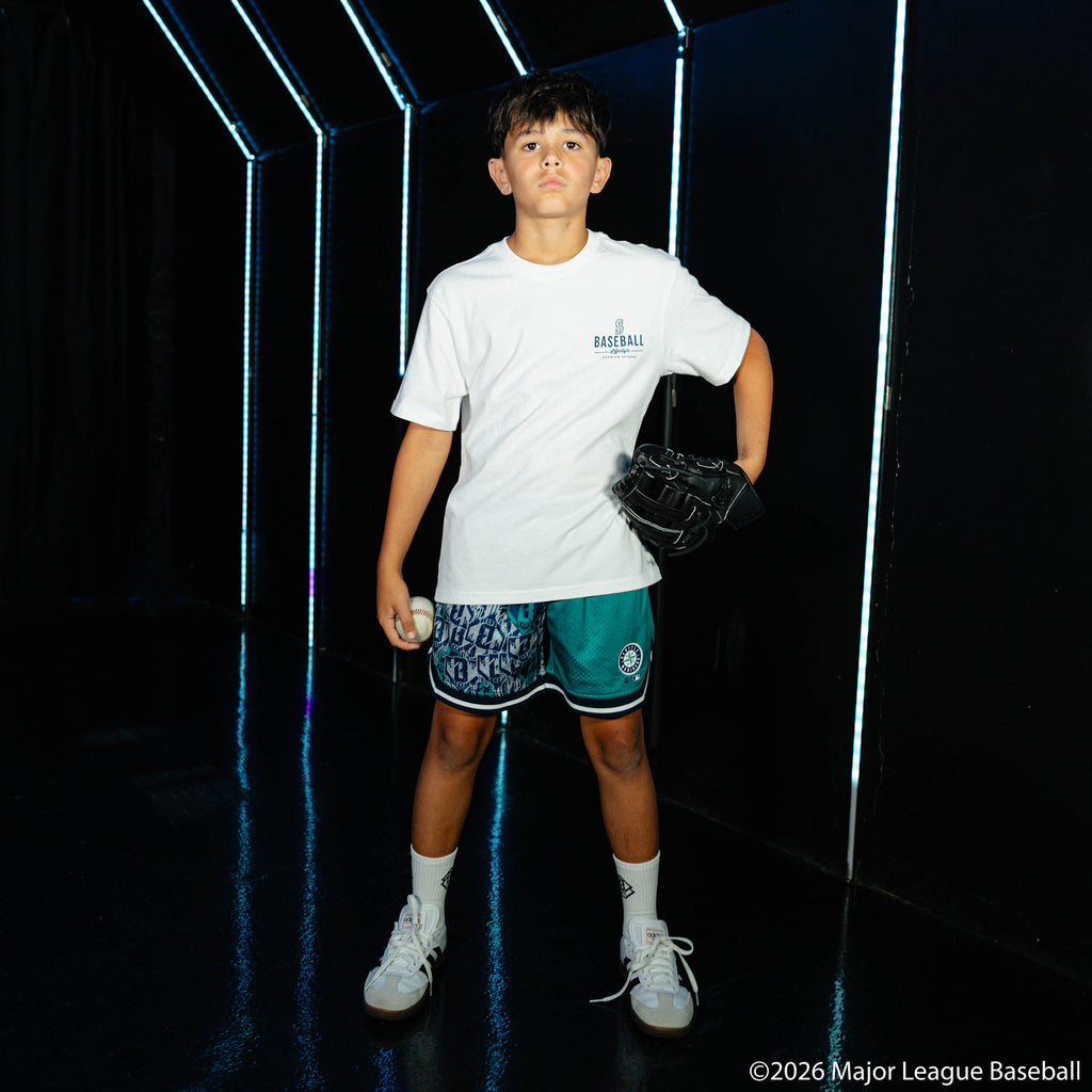 Youth model wearing green youth shorts with "Seattle Mariners Sticker Court" design