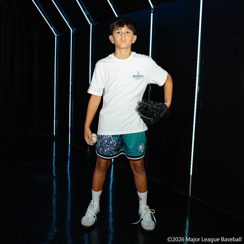 Youth model wearing green youth shorts with "Seattle Mariners Sticker Court" design
