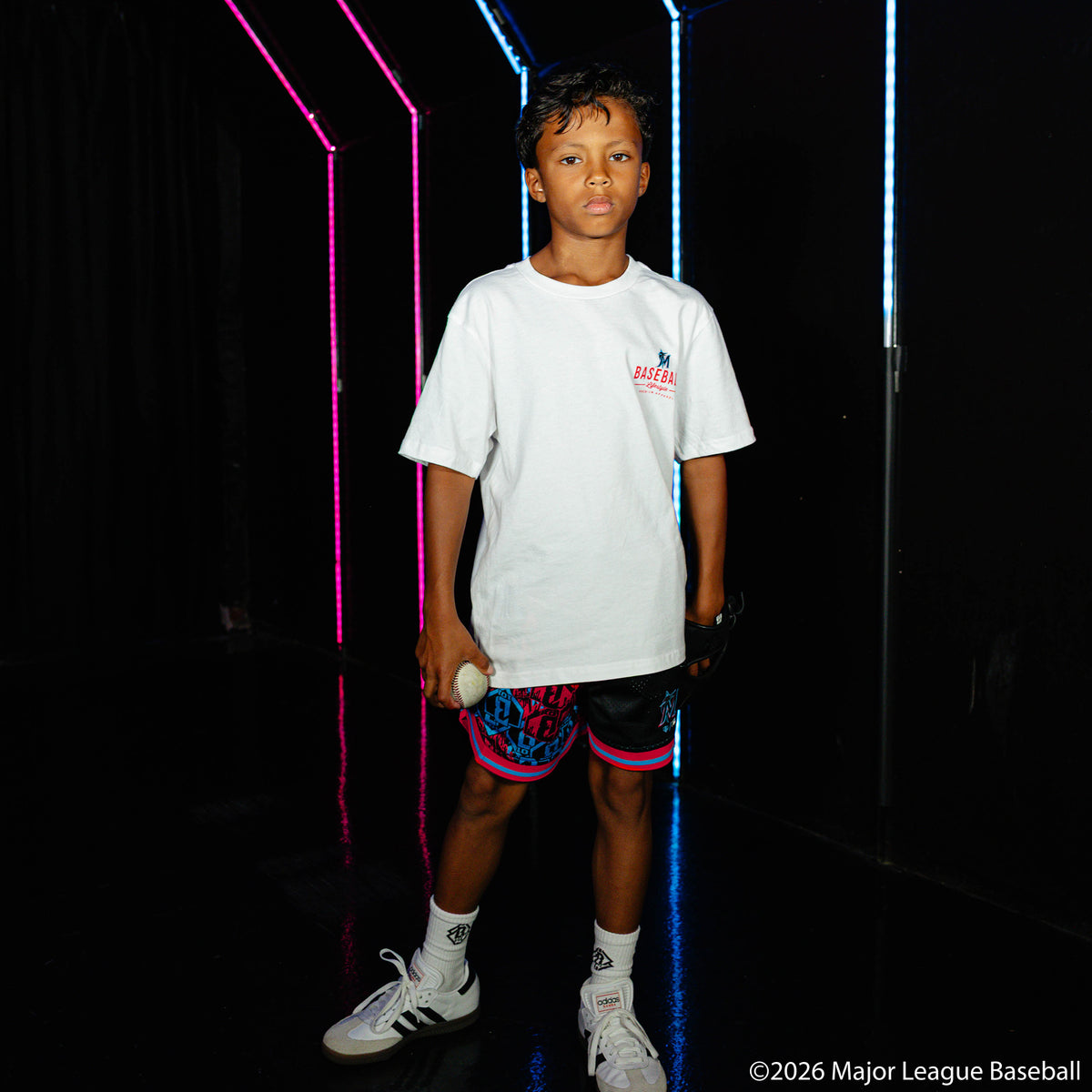 Youth model wearing black youth shorts with "Miami Marlins Sticker Court" design