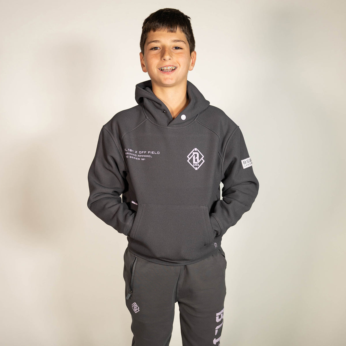 Youth model wearing gray and lilac Off-Field Waffle Performance youth hoodie