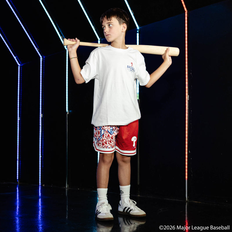Youth model wearing red youth shorts with "Philadelphia Phillies Sticker Court" design