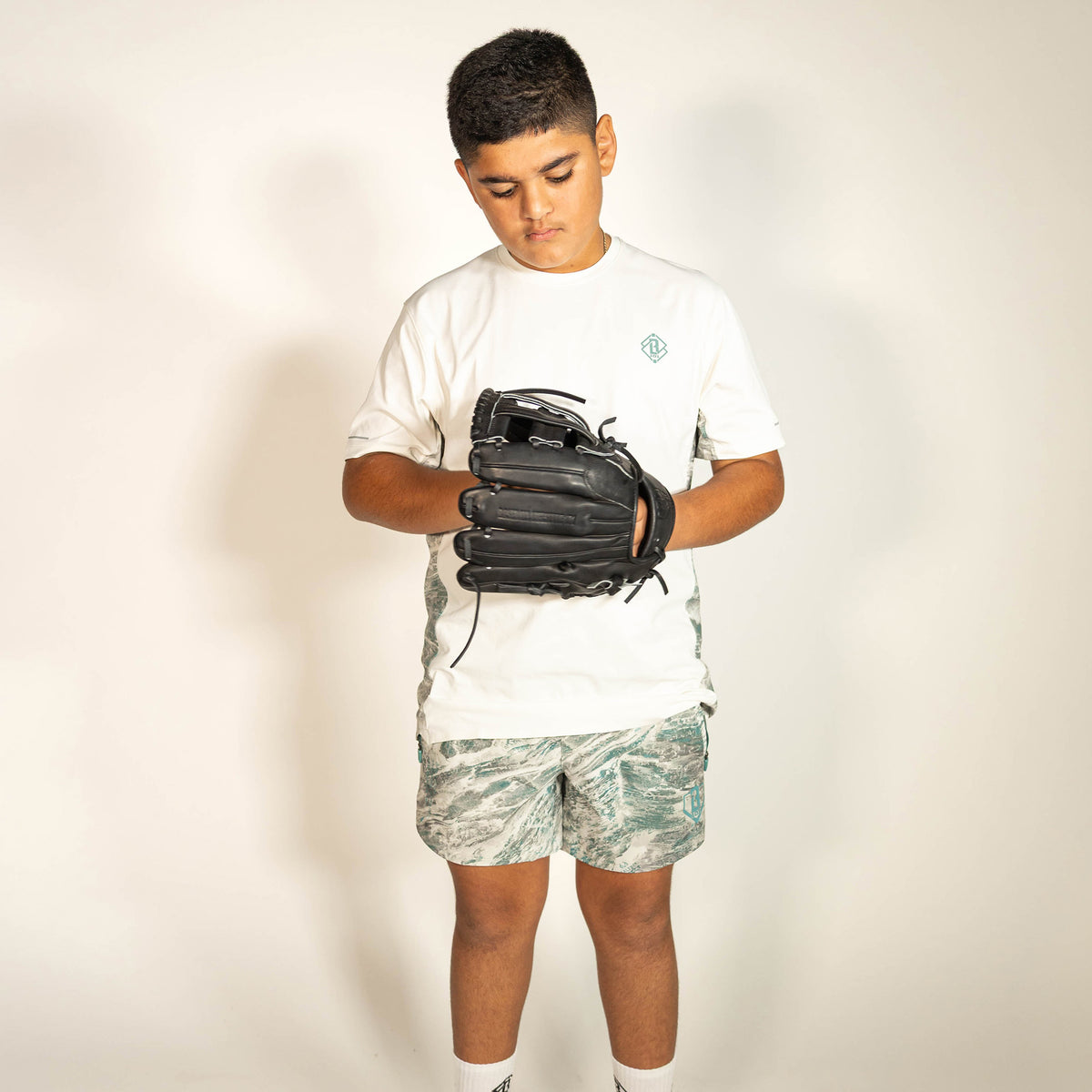 Youth model wearing gray Realtree Aspect Pro Series V2 Camo youth shorts with liner