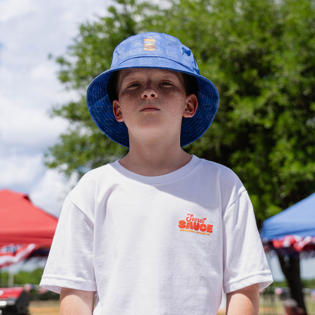 Young male model wearing blue burger print bucket hat standing outdoors