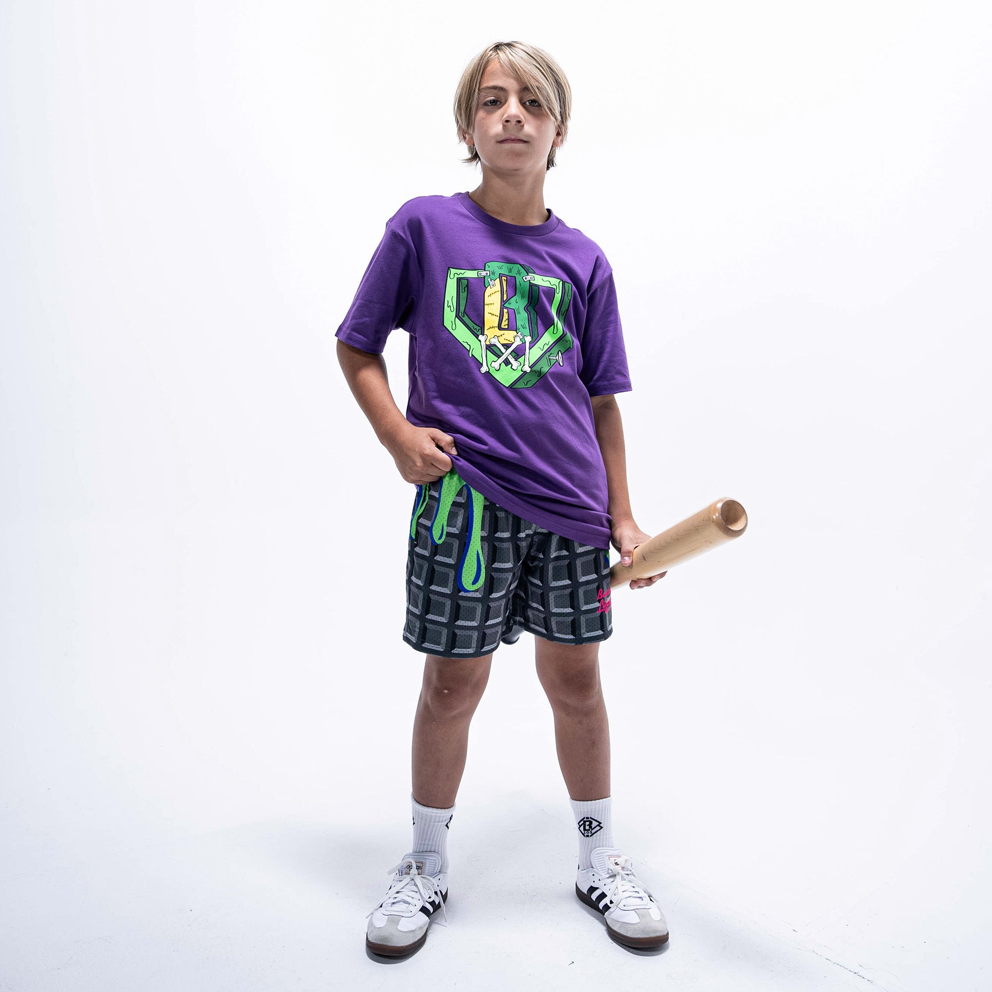 Youth model wearing purple youth graphic tee with "Spooky SZN Stitch" design