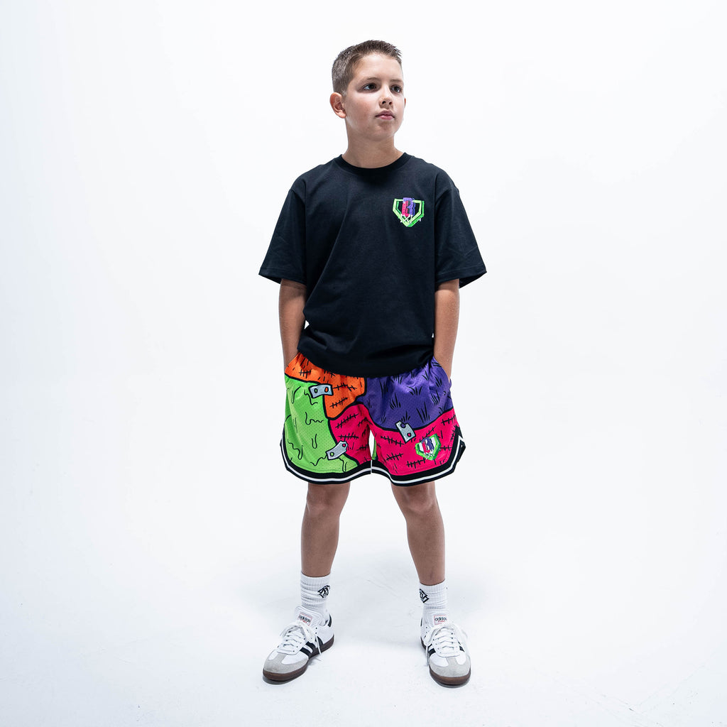 Youth model wearing multi-color youth shorts with "Stitched For The Show" design