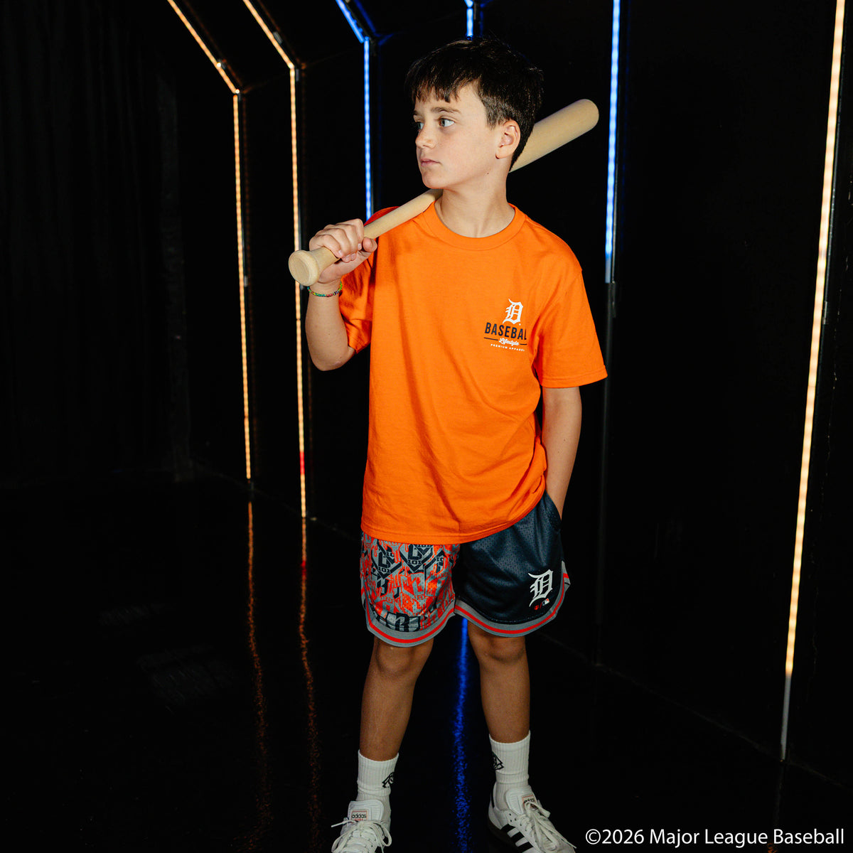 Youth model wearing navy youth shorts with "Detroit Tigers Sticker Court" design