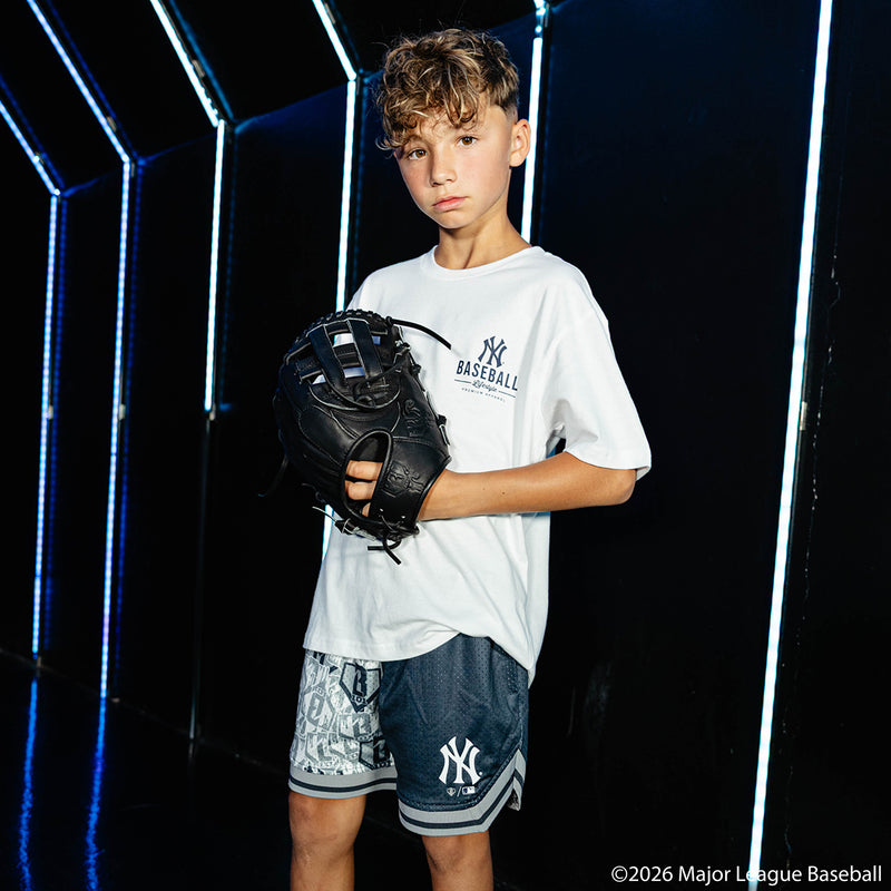 Youth model wearing navy youth shorts with "New York Yankees Sticker Court" design