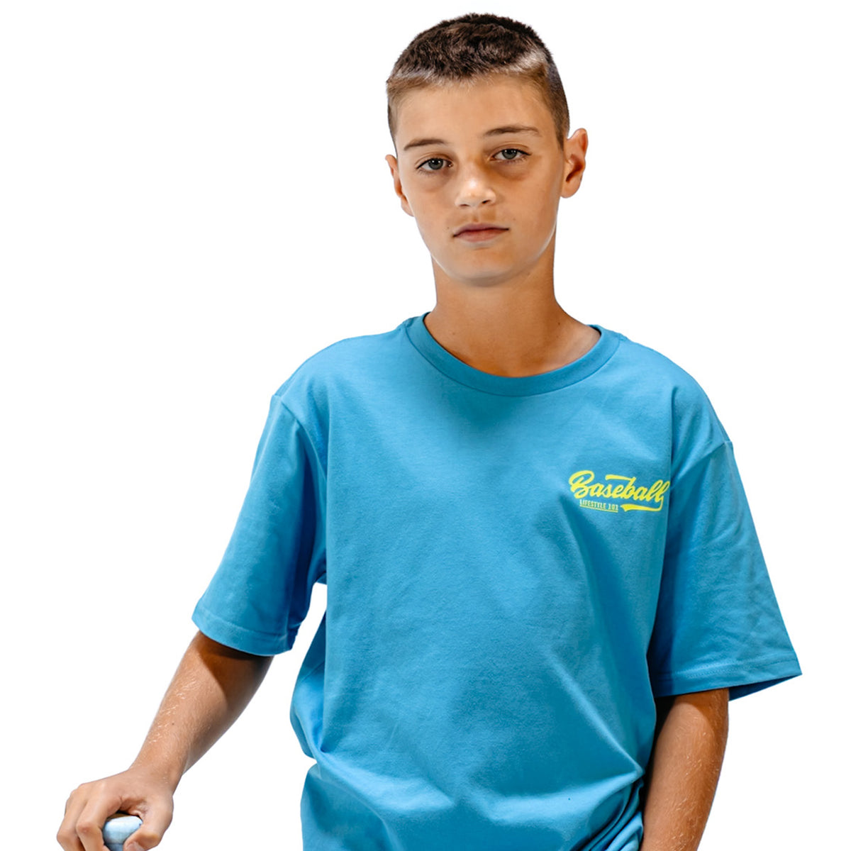 Child wearing a blue t-shirt with yellow 'Baseball Lifestyle 101' logo in top right corner