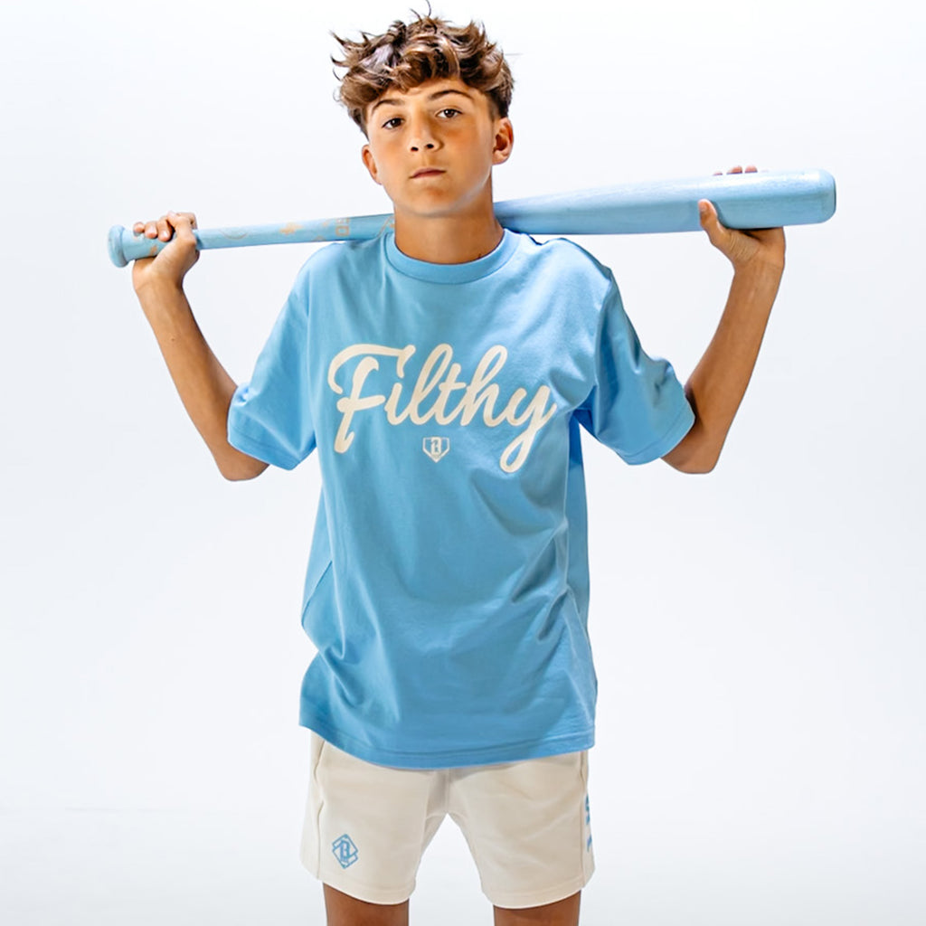 Person wearing a light blue t-shirt with white 'Filthy' text, holding a light blue baseball bat against a white background.